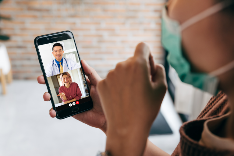 Patient having a remote video call with their doctor, adding an interpreter to the call to guarantee every word is understood.